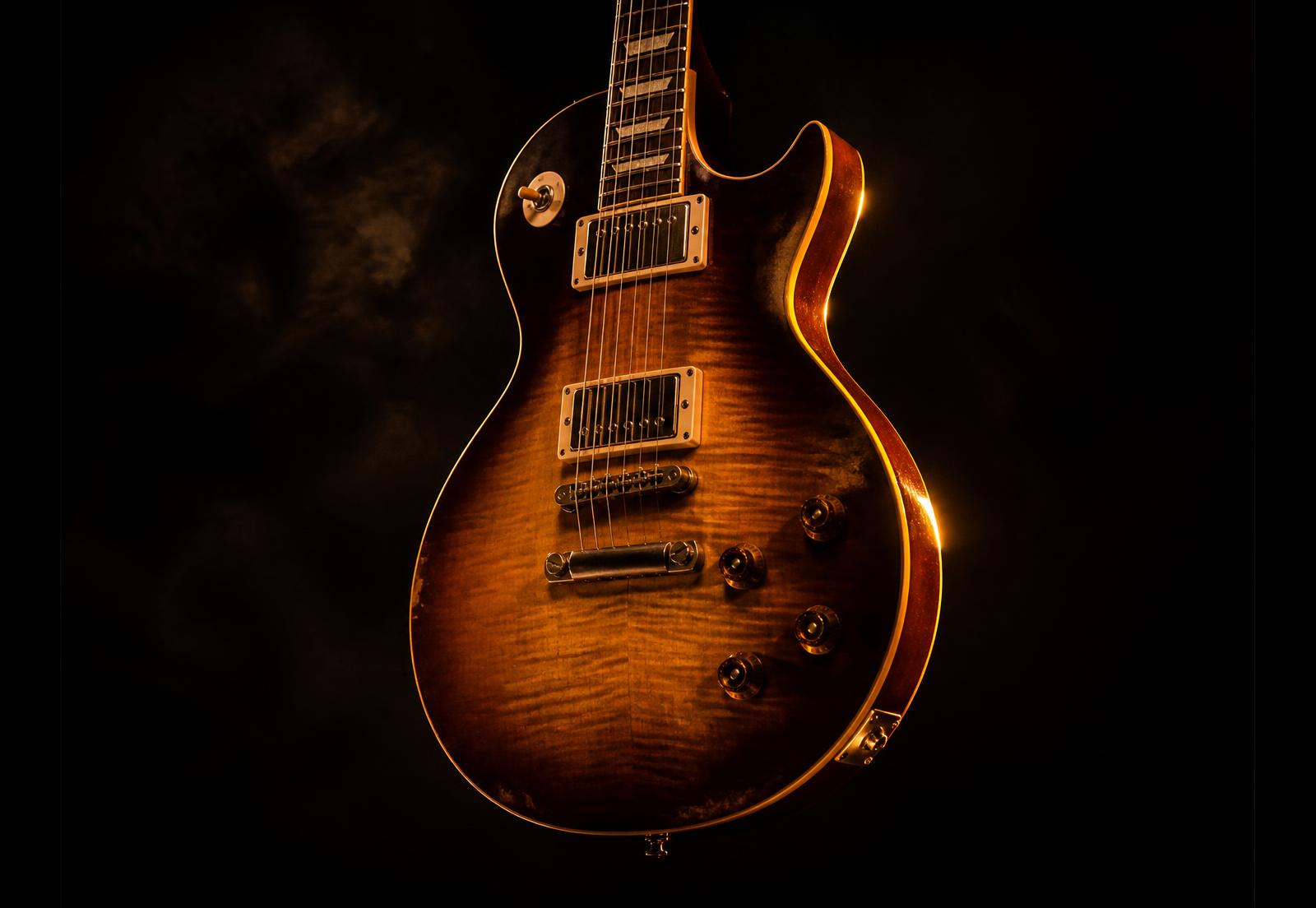 Sunburst electric guitar lit by warm golden light in a dark studio
